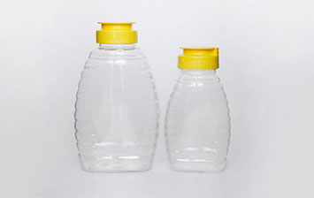 Plastic queenline jar for honey storage with yellow sealed lids